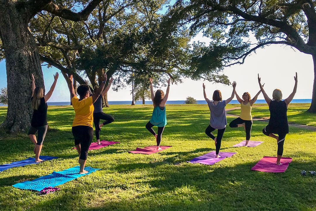 Students practicing yoga on campus near the beach